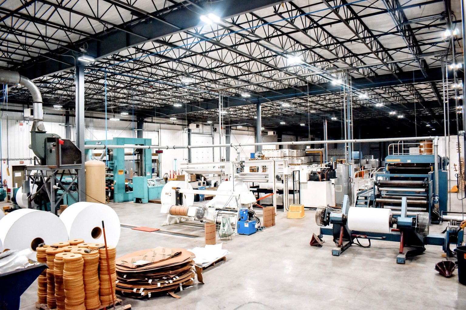 a large warehouse filled with lots of machinery and rolls of paper