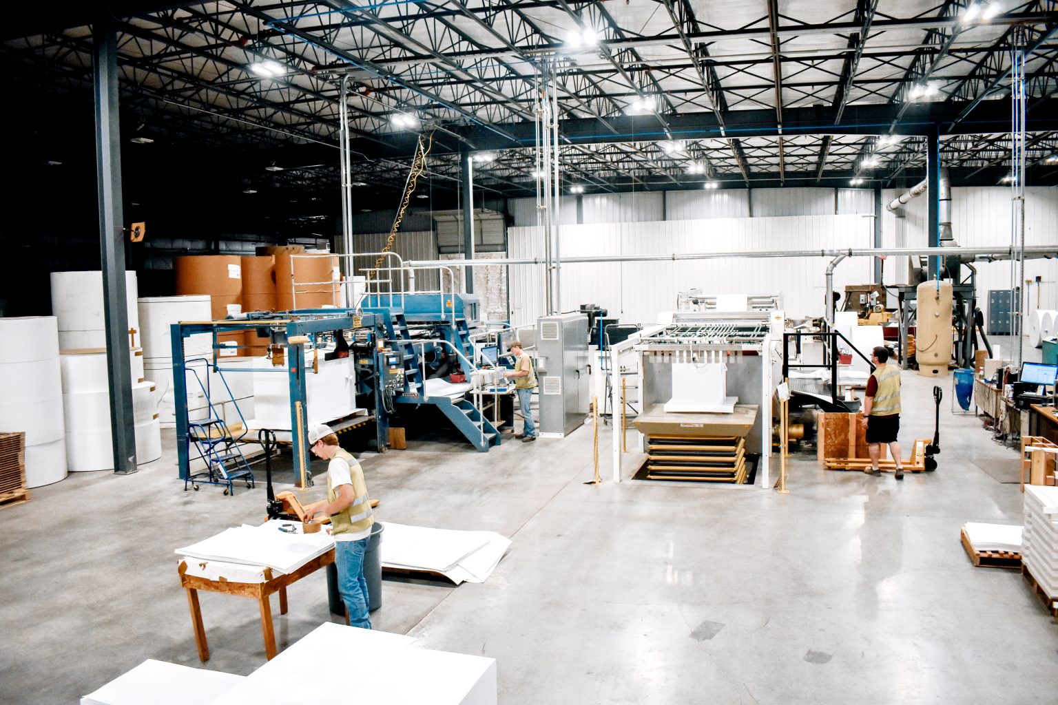 man in green vest working in sheeter side of warehouse