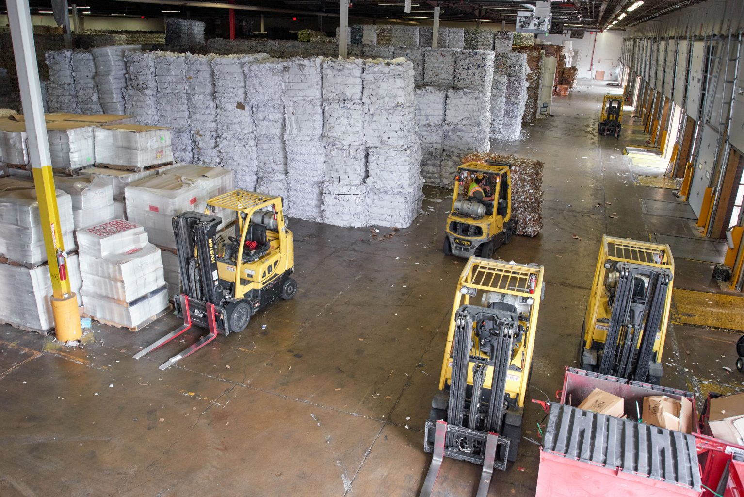 several forklifts are working in a large warehouse